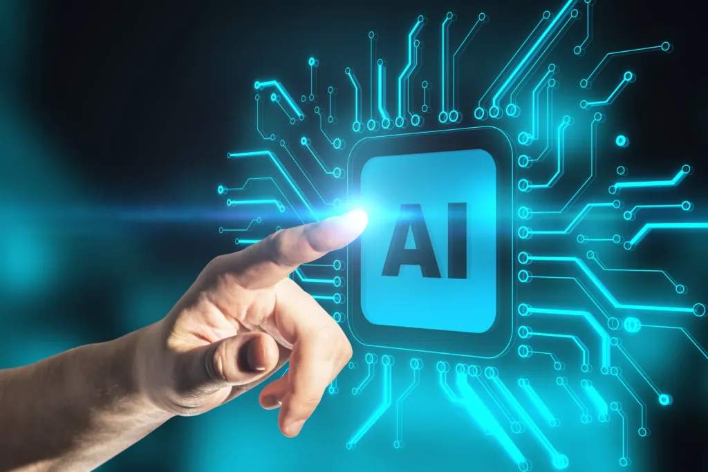 A hand touches a glowing digital interface displaying the letters "AI," surrounded by circuit-like lines representing artificial intelligence technology.